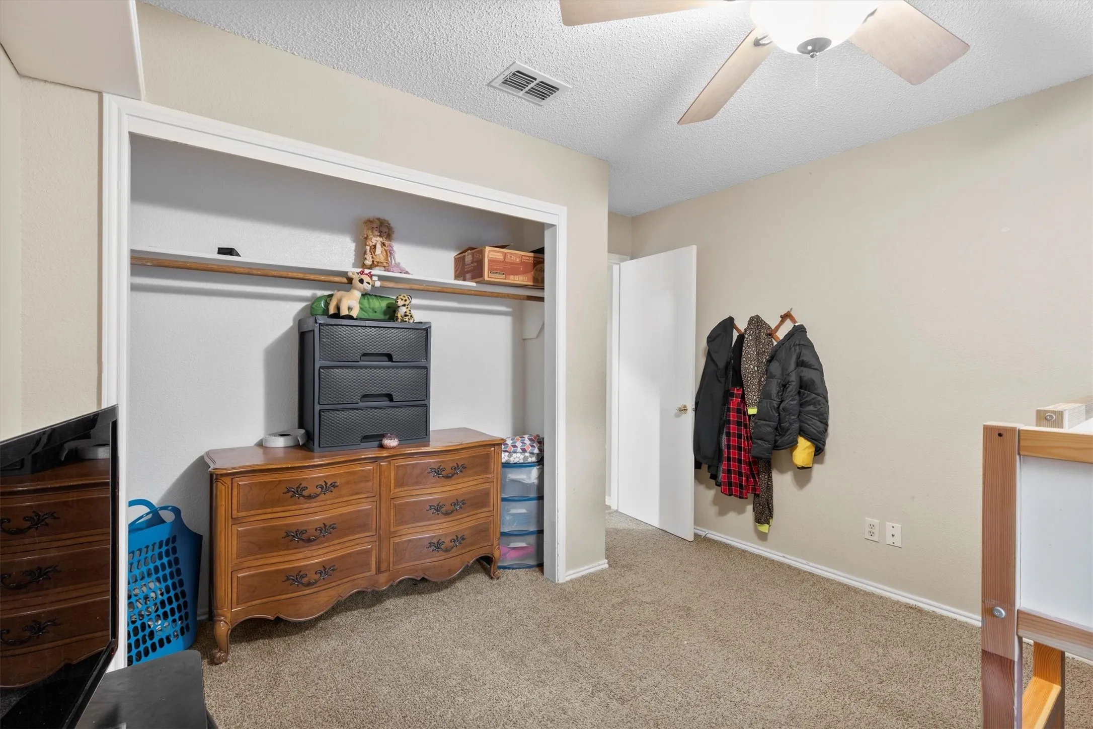 Carpeted bedroom with a textured ceiling and a ceiling fan