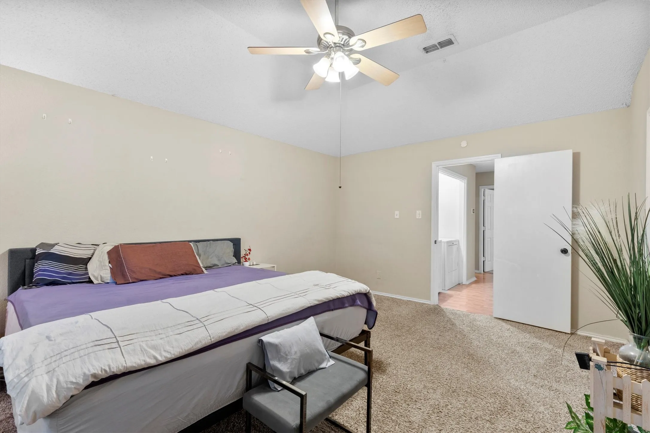 Bedroom with light colored carpet, vaulted ceiling, and ceiling fan