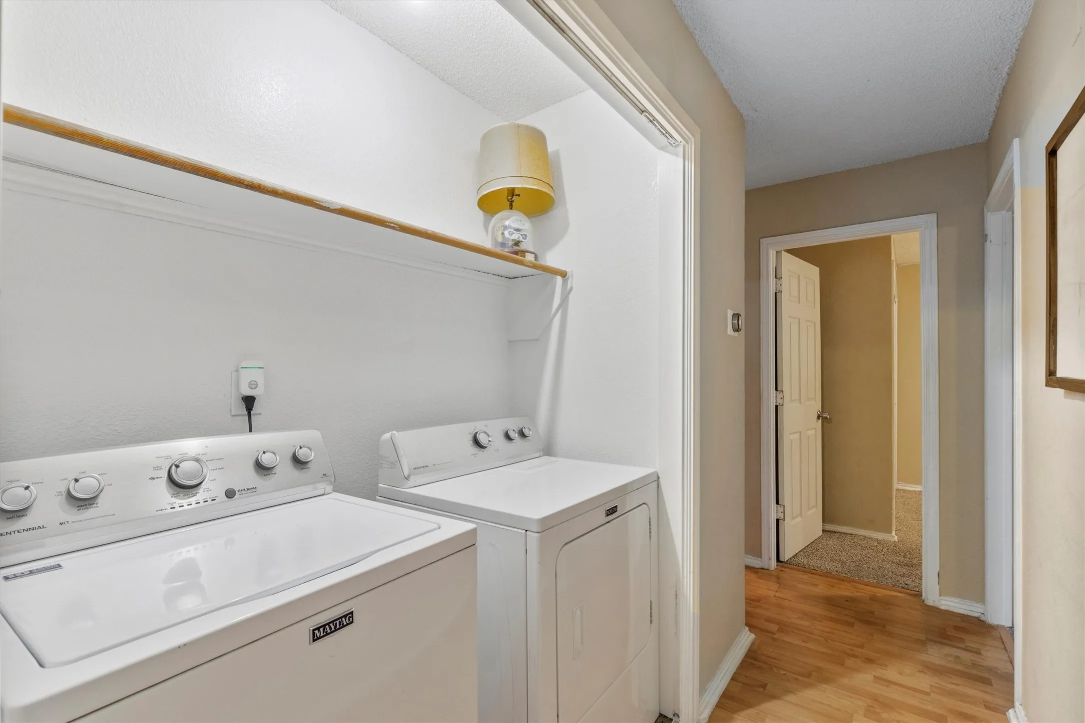 Laundry area with light wood-style flooring and separate washer and dryer