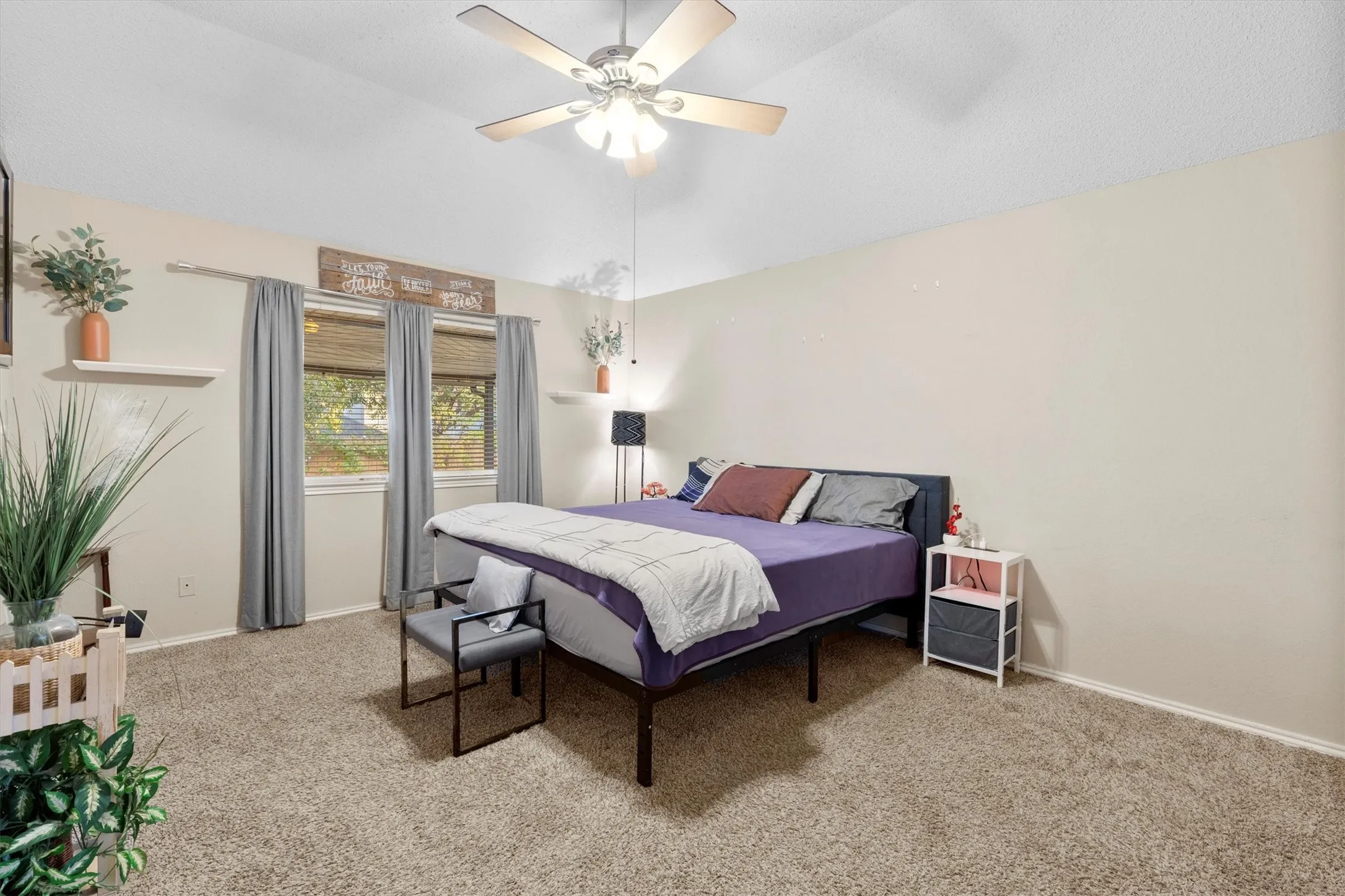 Bedroom with vaulted ceiling, light colored carpet, and a ceiling fan