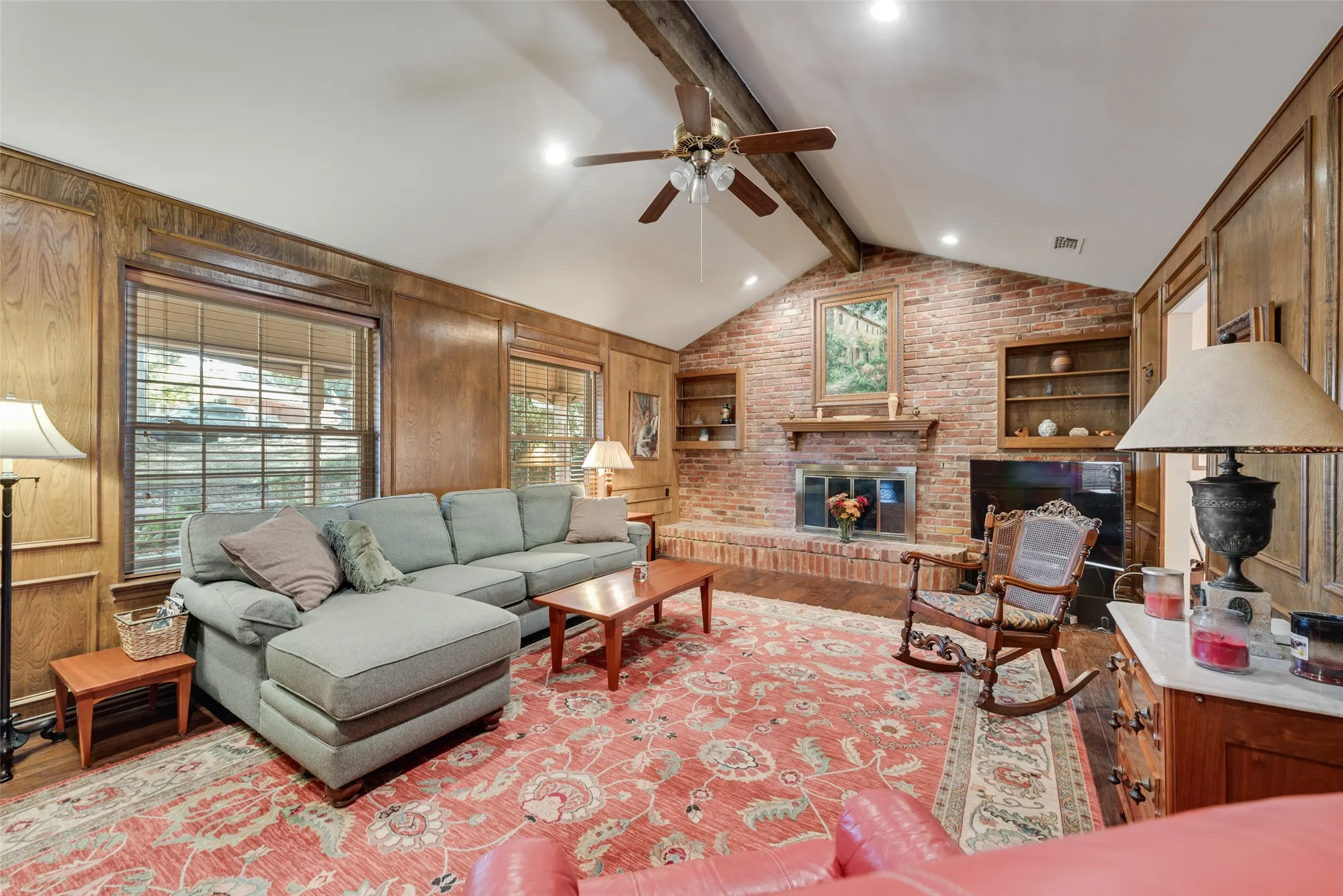 Cozy living room with large windows facing the front of the house and a comfy fireplace