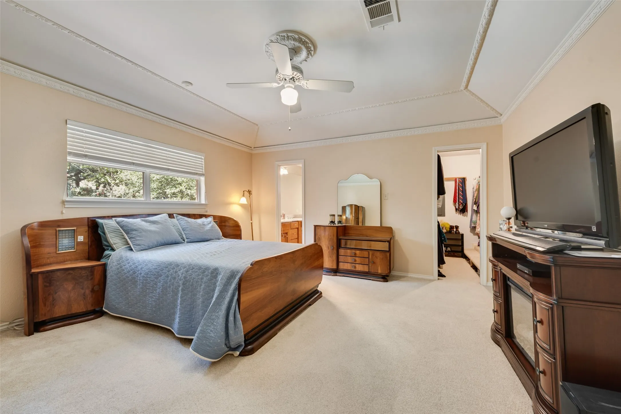 Spacious primary bedroom with vaulted ceiling and large walk-in closet