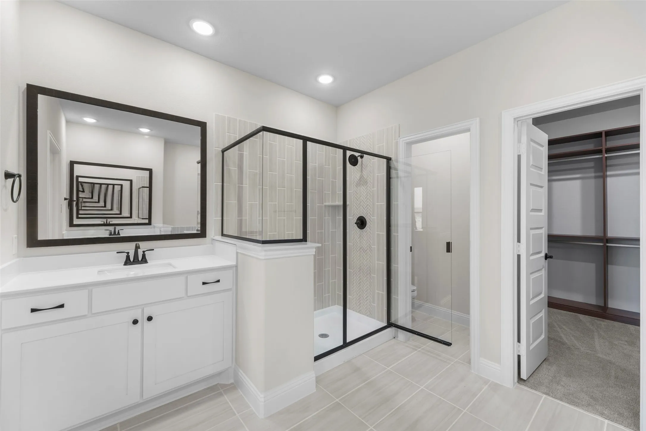 White vanity with a rectangular sink, black framed mirror, and matte black fixtures