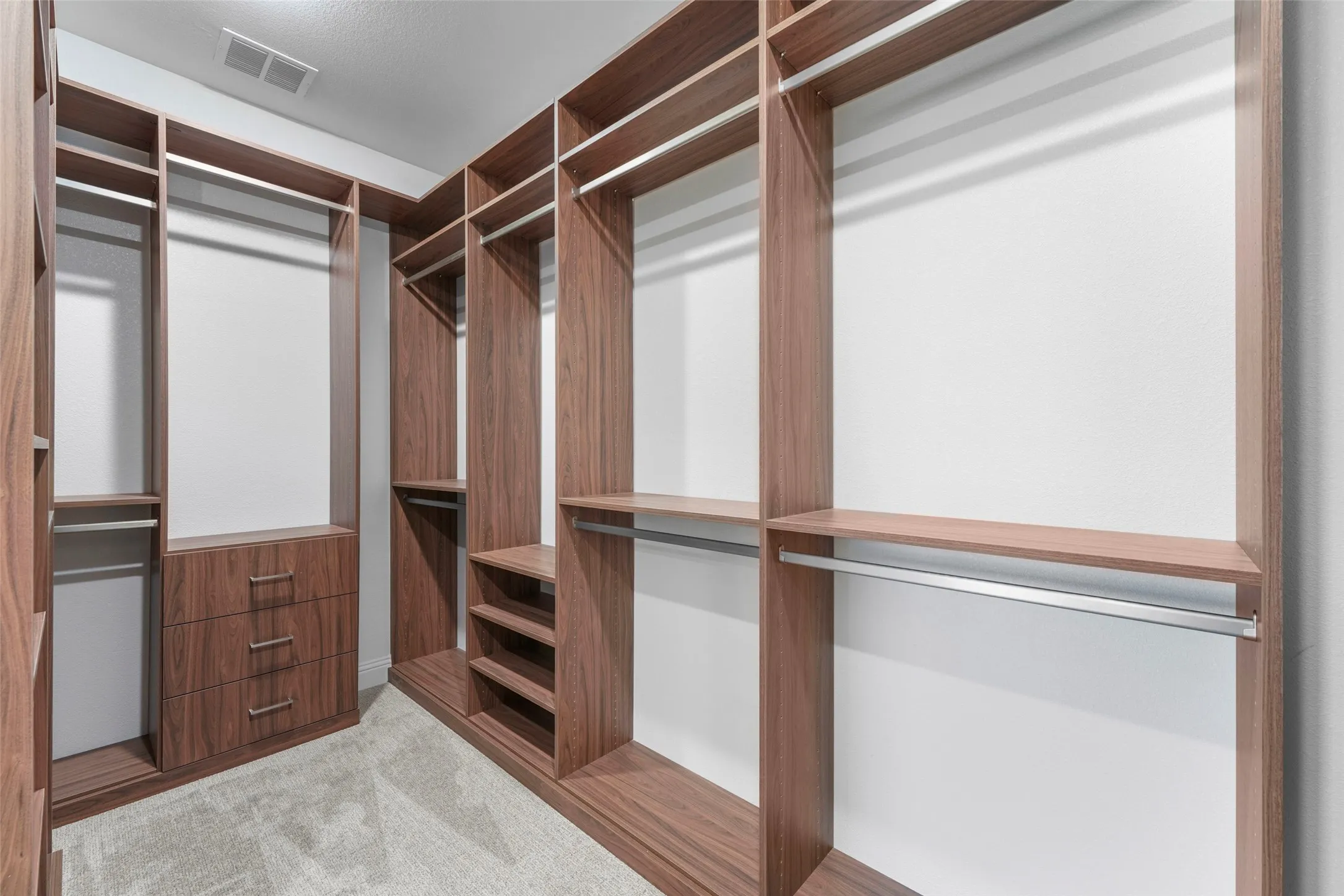 Custom wood-finish closet system featuring integrated drawers, shelving, and hanging rods