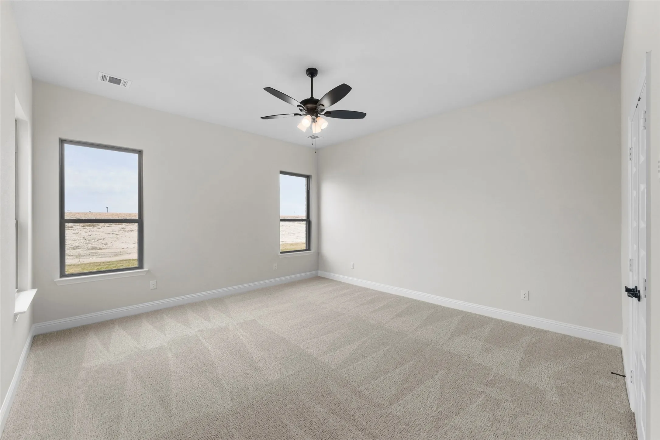 Vaulted ceiling, two windows, ceiling fan, and carpeted flooring