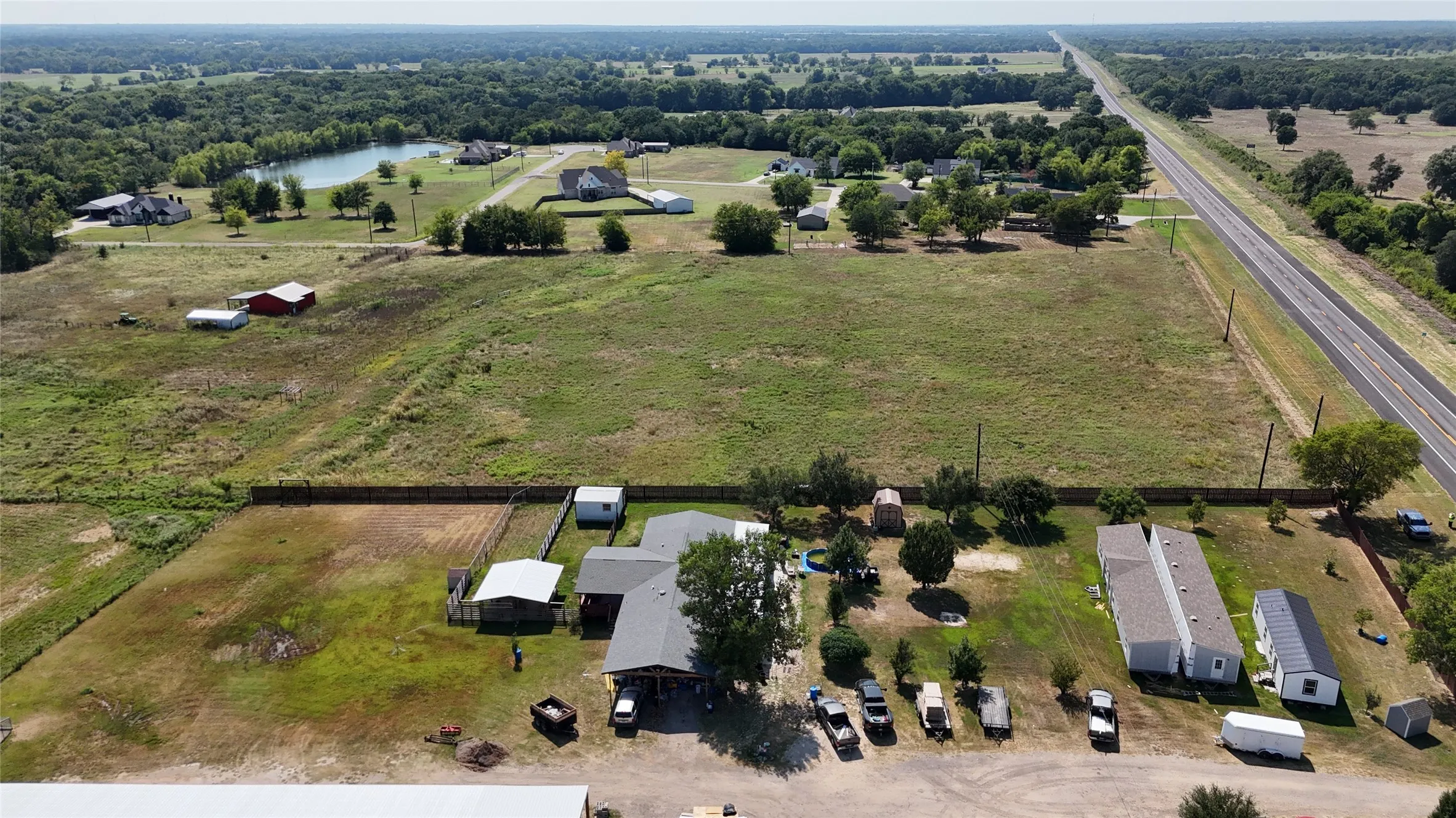 Expansive acreage featuring multiple structures, including a primary residence, several outbuildings, and a manufactured home
