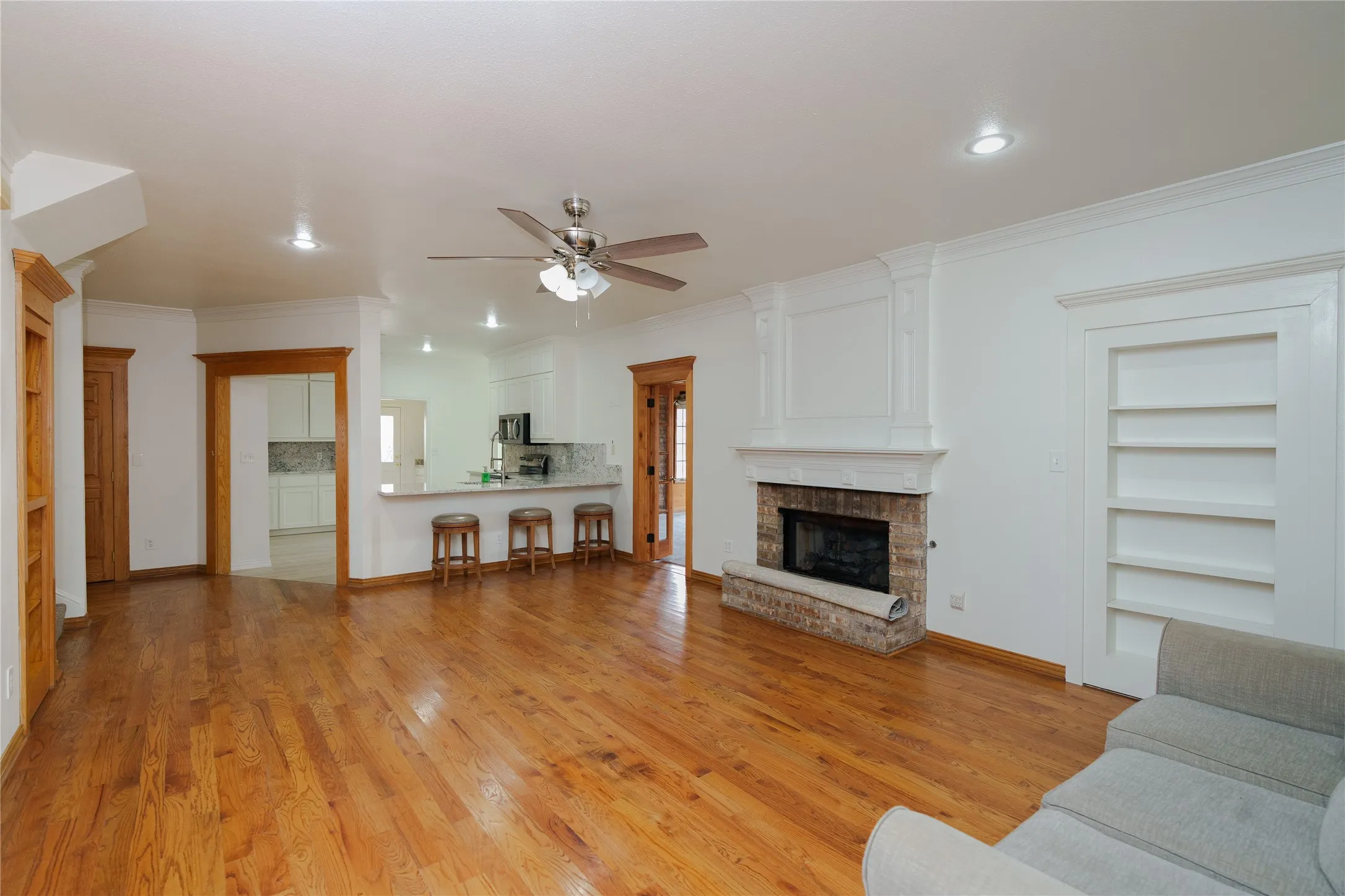 Living area is open to the kitchen with a fireplace and built in bookshelves that are doors to closets.