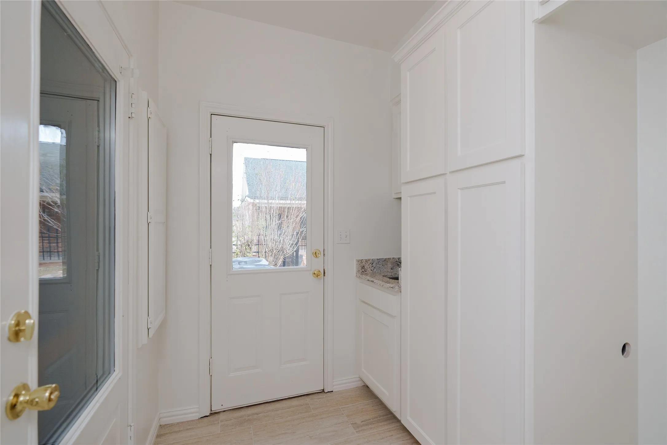 Full Size Stackable Washer Dryer Space with Cabinets and a sink.