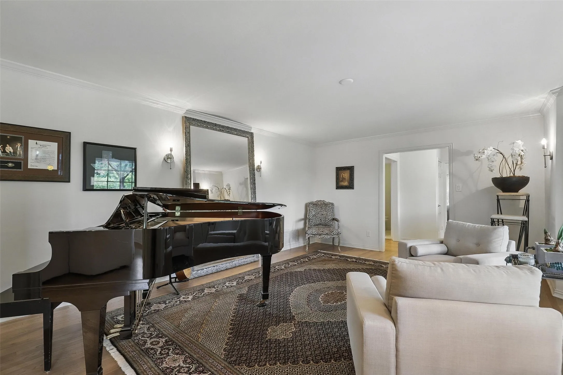Living area with wood finished floors and ornamental molding