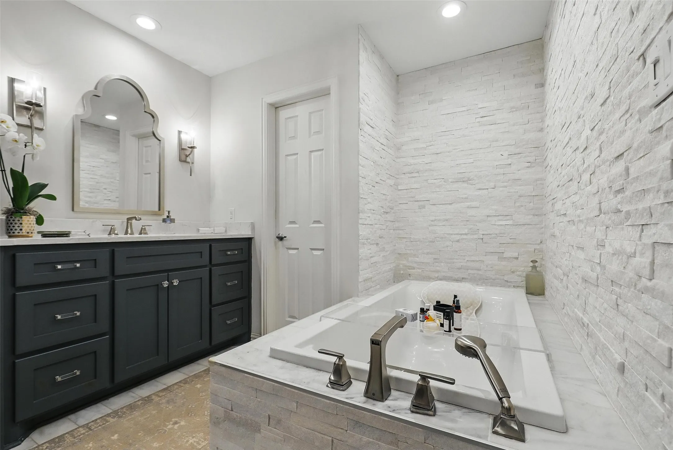 Bathroom featuring vanity, a bath, and recessed lighting