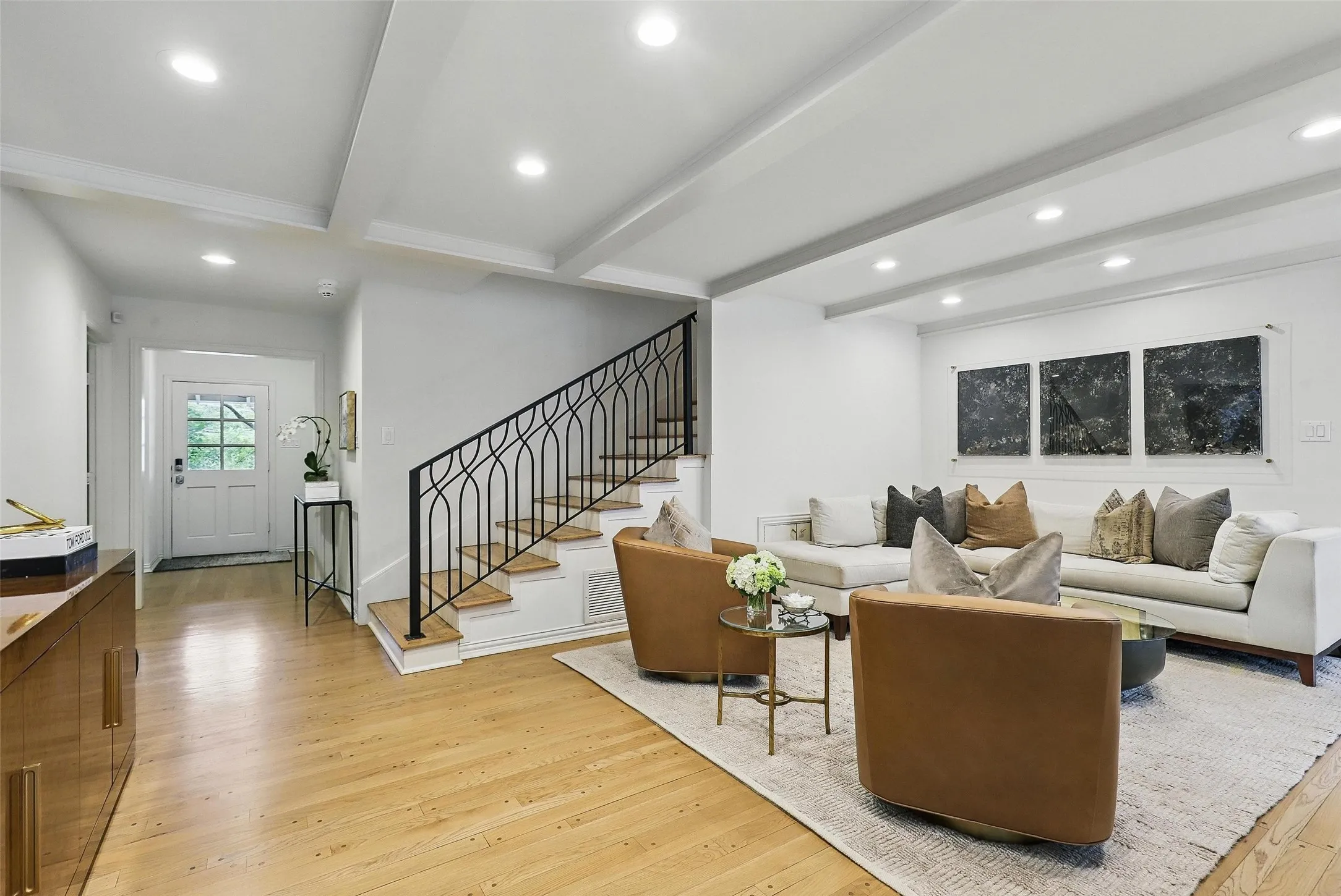 Living area featuring beam ceiling, light wood-type flooring, stairs, and recessed lighting