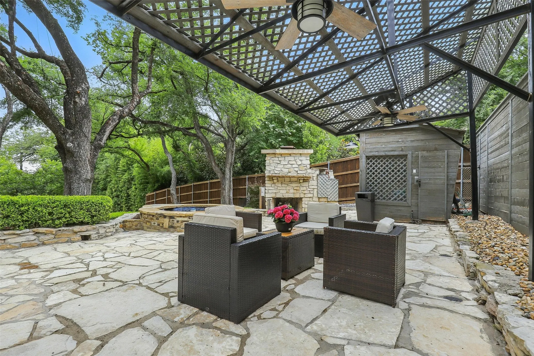 Fenced backyard featuring a patio, an outdoor living space with a fireplace, and a ceiling fan