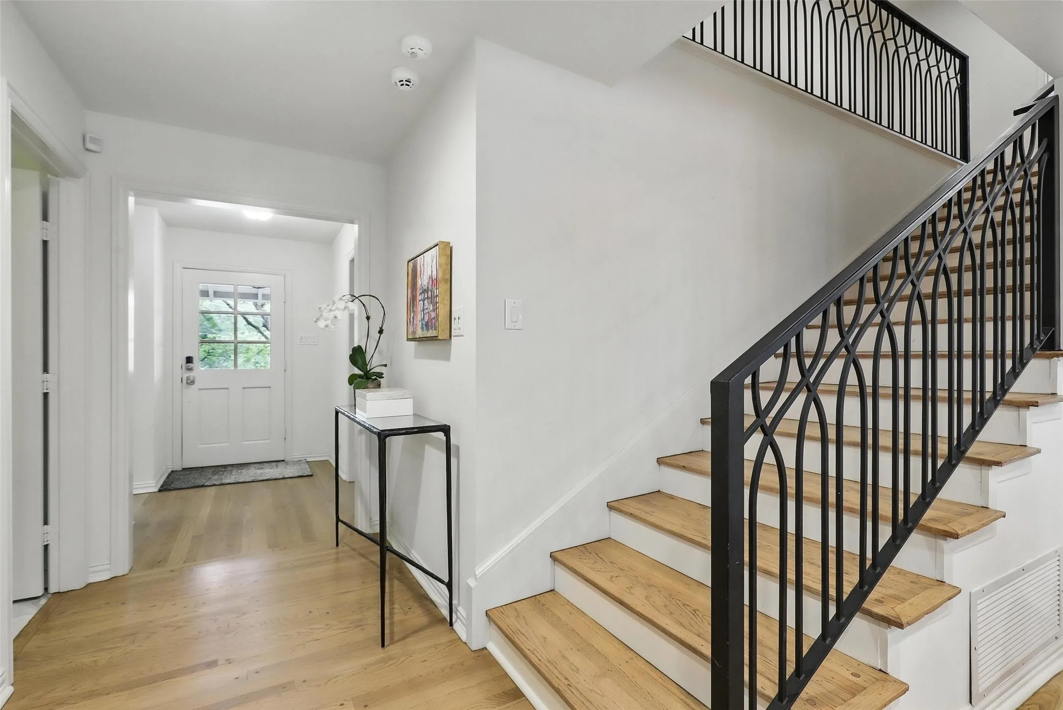 Entrance foyer with light wood-style flooring and stairs
