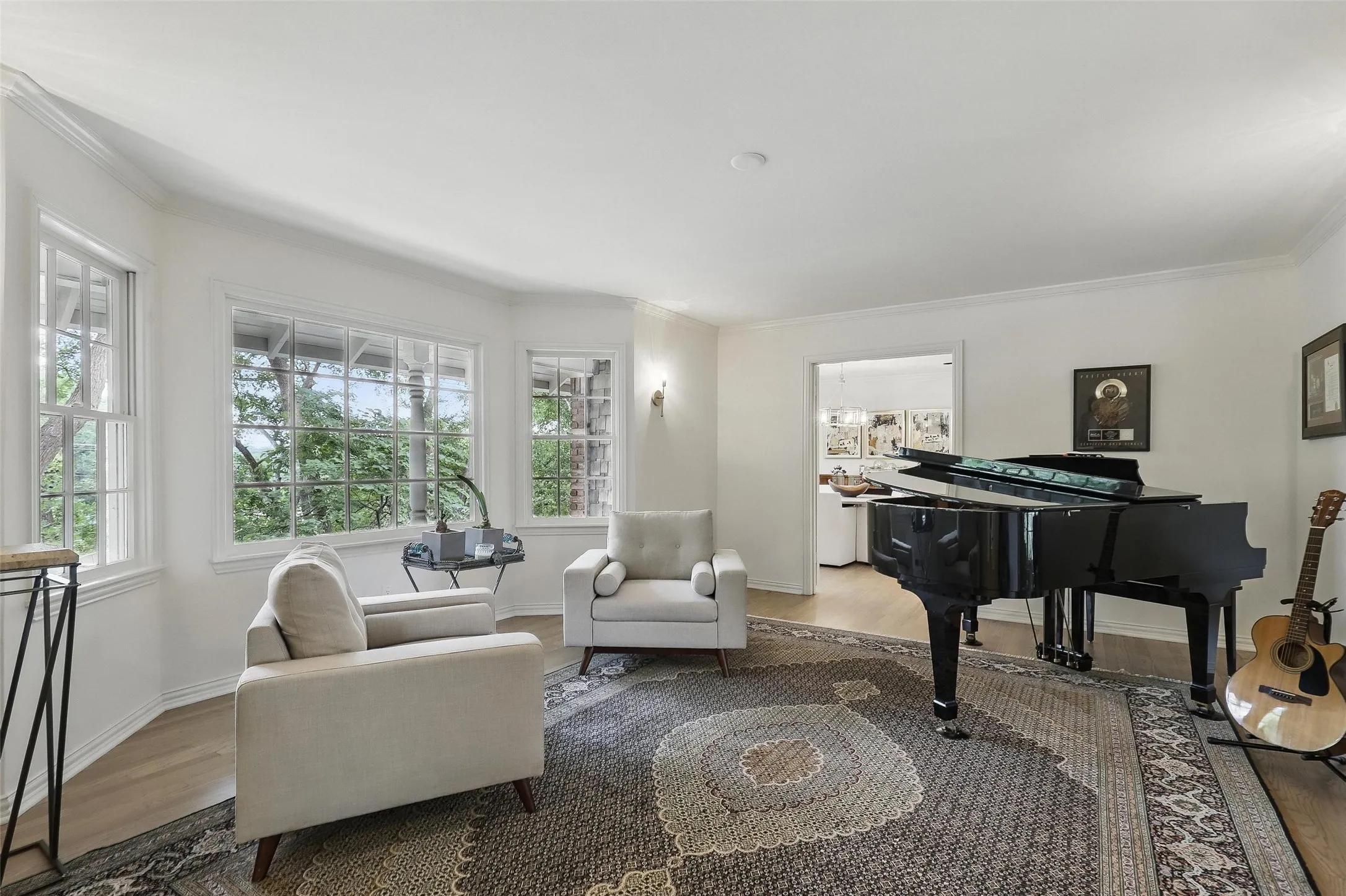 Living area with ornamental molding and wood finished floors