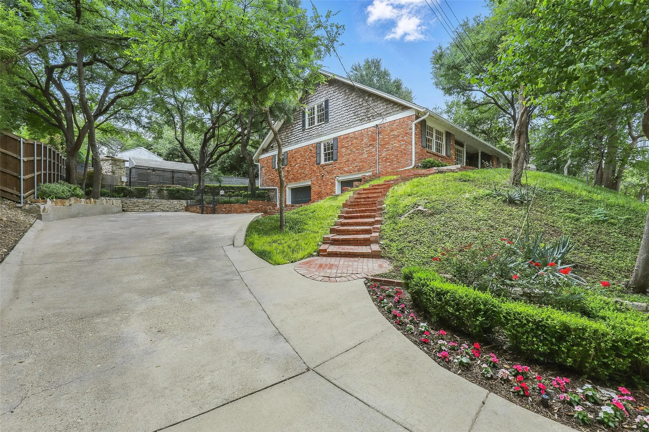 View of side of property featuring stairs, concrete driveway, a garage, and brick siding