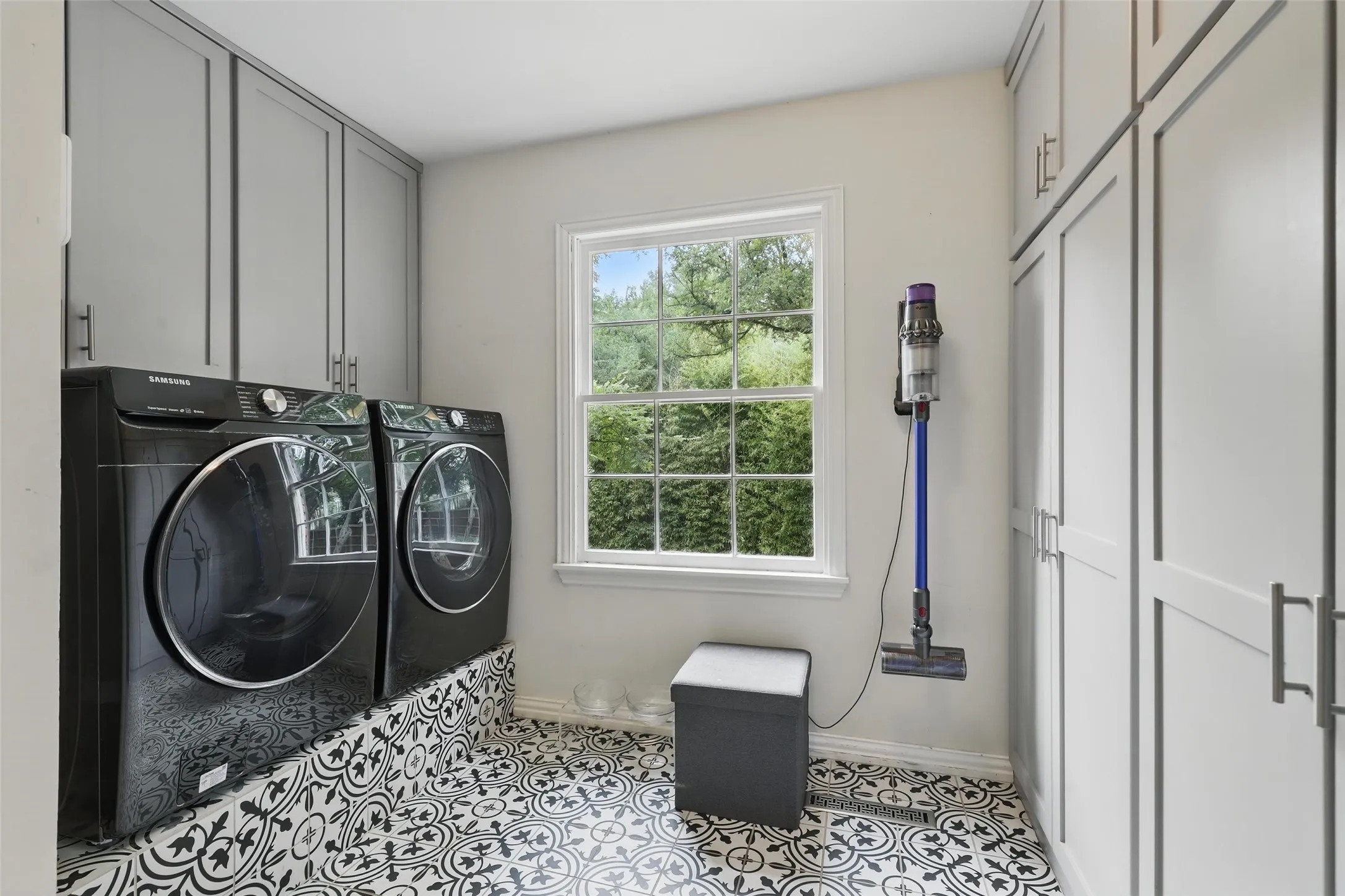 Washroom with cabinet space, independent washer and dryer, and light tile patterned floors