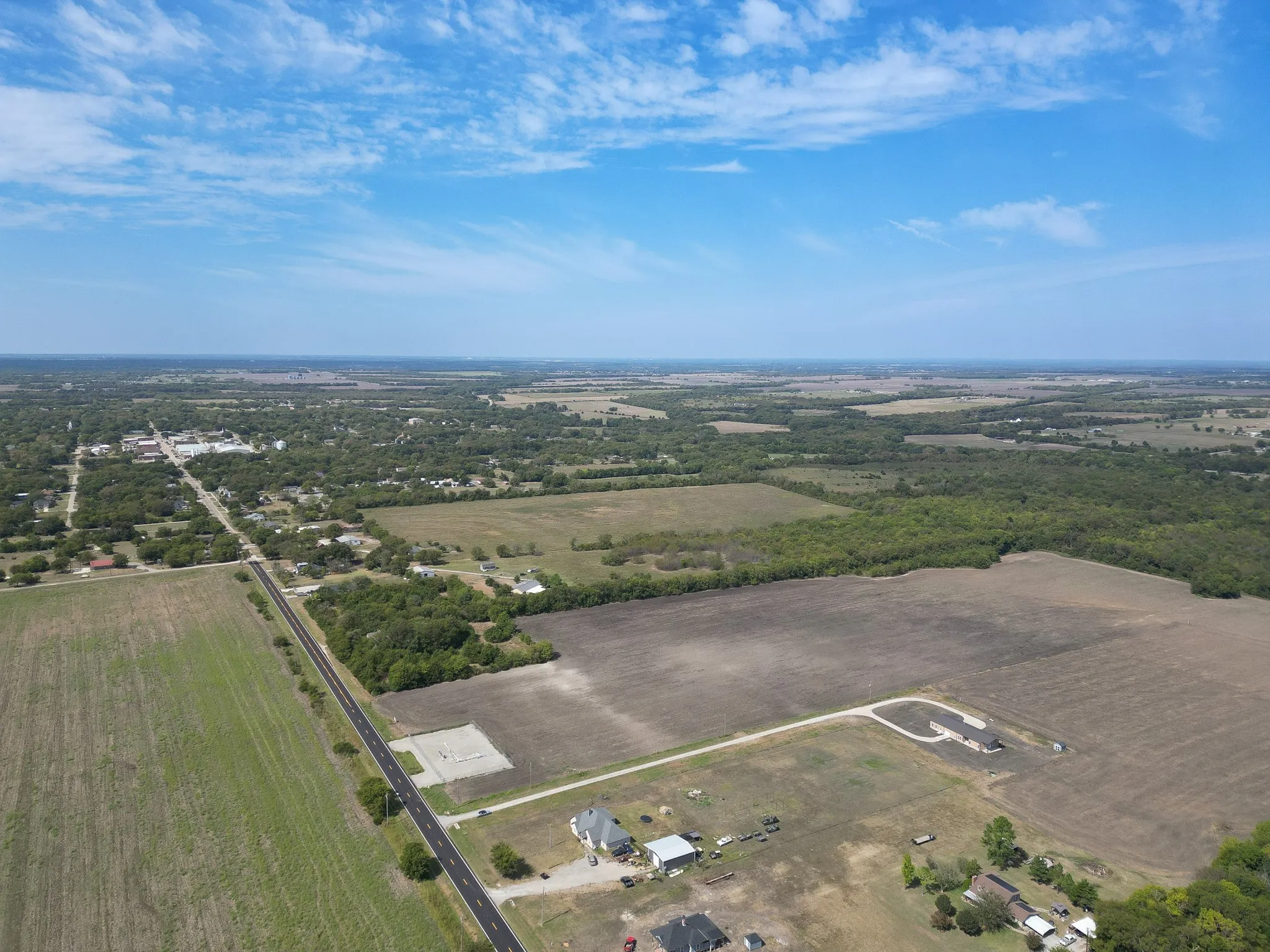 Aerial view of property and surrounding area featuring rural landscape and property parcel outlined