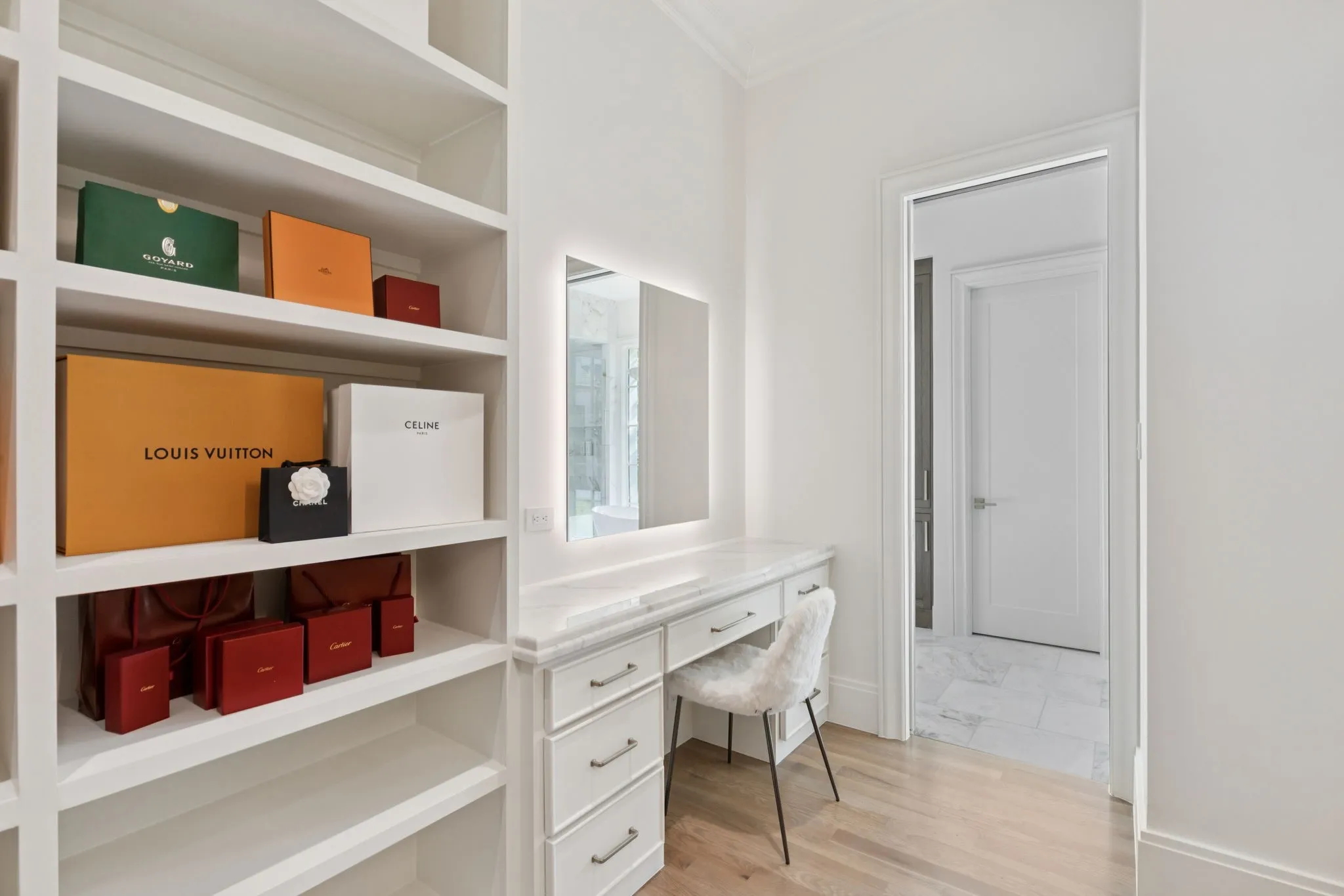 Office space featuring light wood finished floors, built in desk, and crown molding