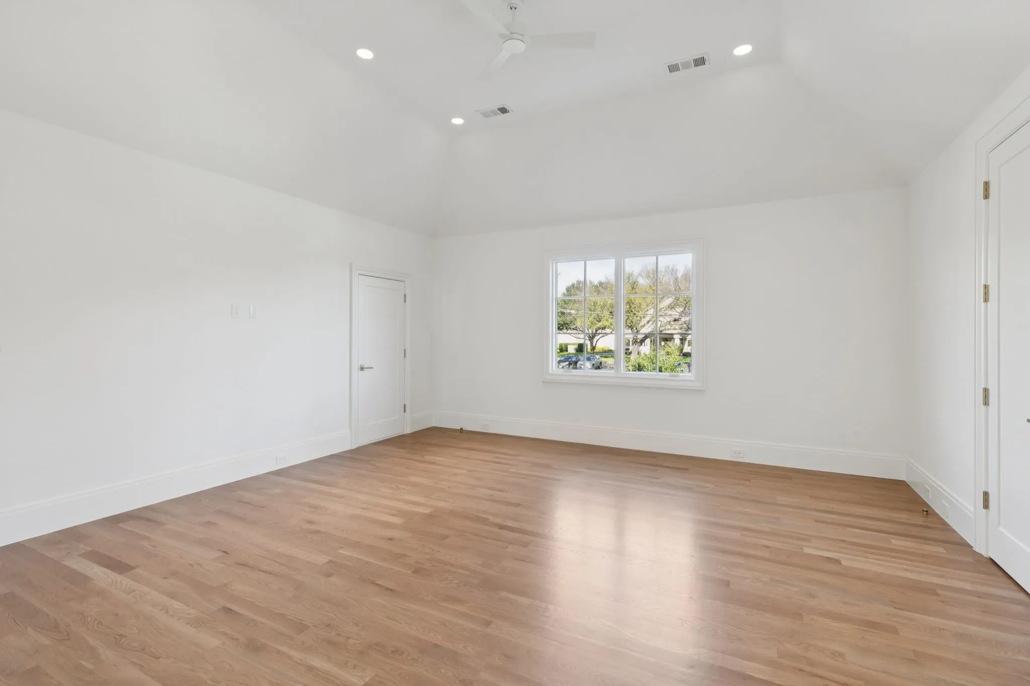 Spare room with light wood-style flooring, ceiling fan, vaulted ceiling, and recessed lighting