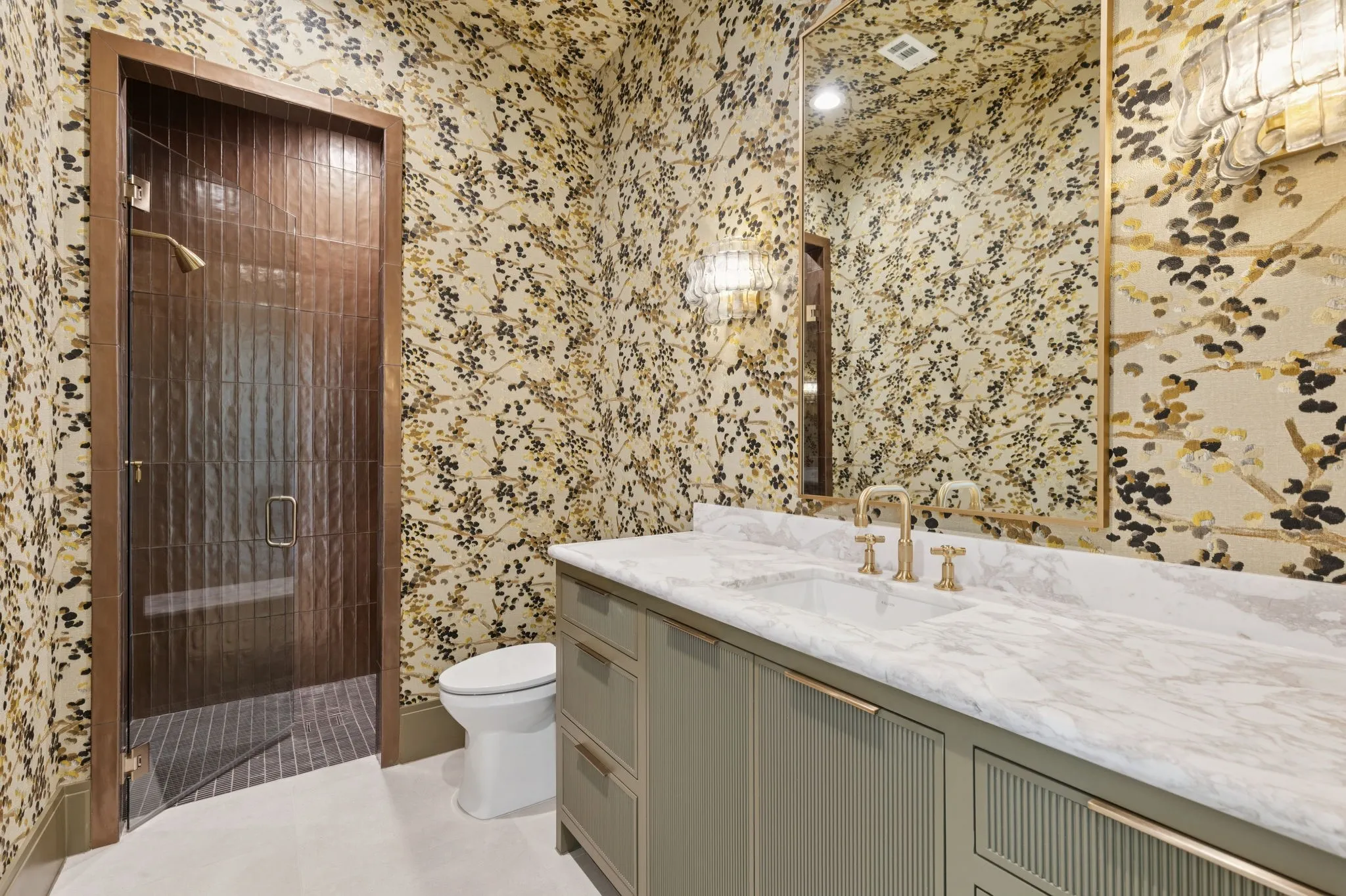 Bathroom featuring a shower stall, wallpapered walls, and vanity