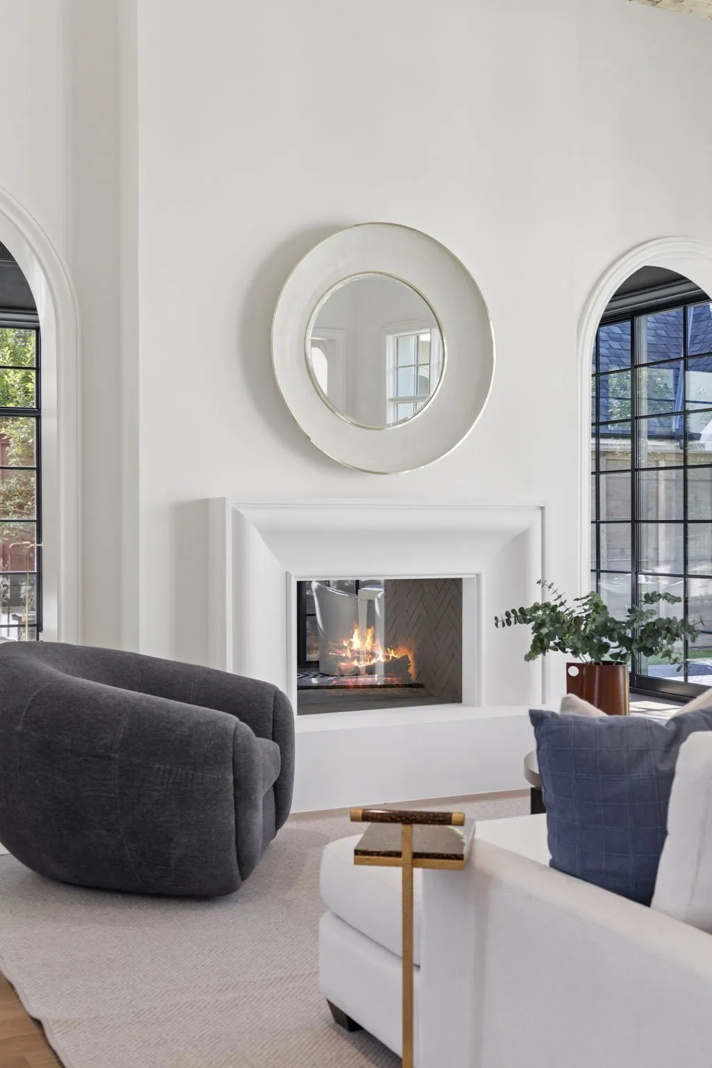 Living room featuring healthy amount of natural light, a lit fireplace, and a high ceiling
