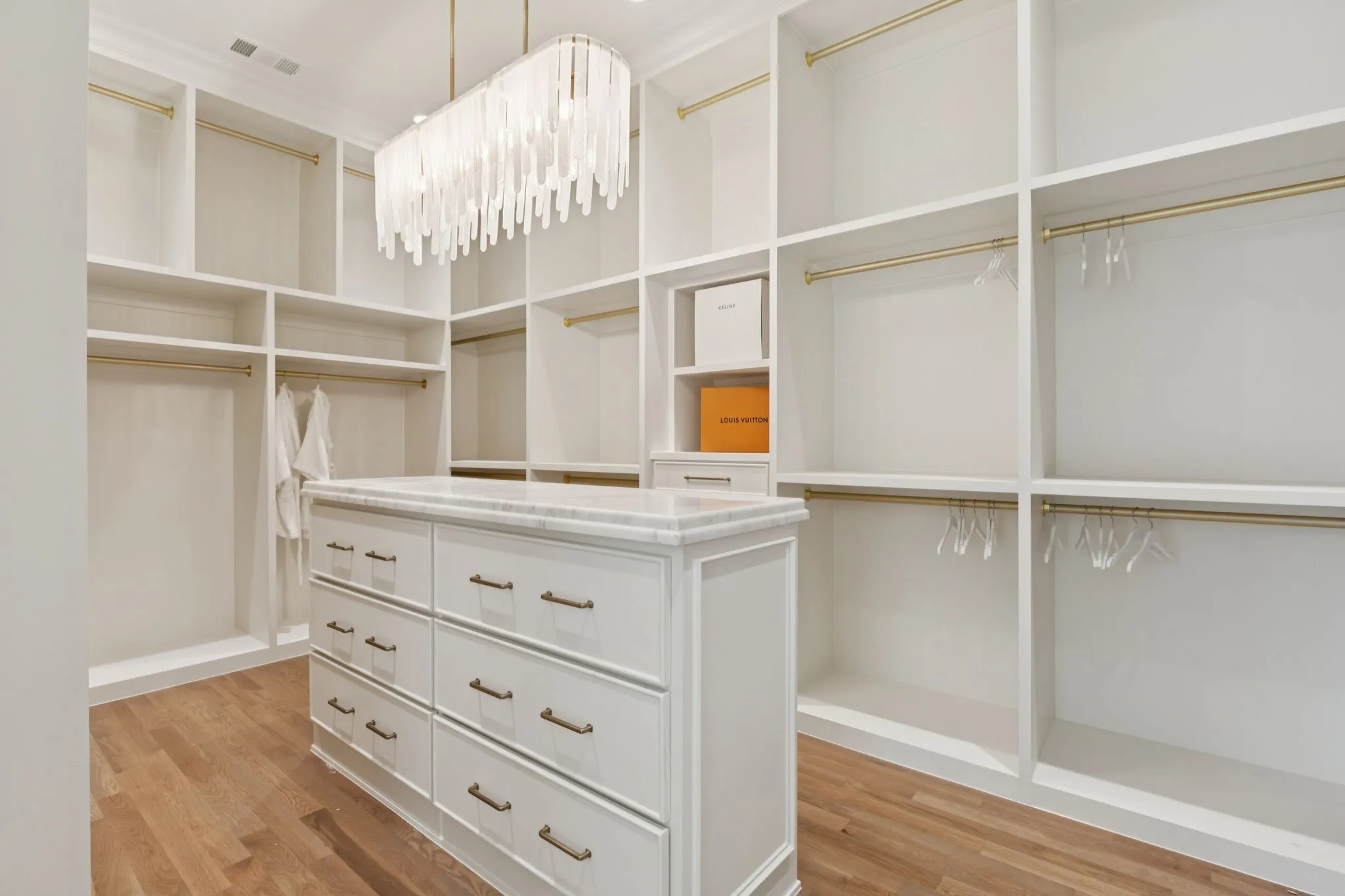 Spacious closet featuring light wood-style floors and a chandelier