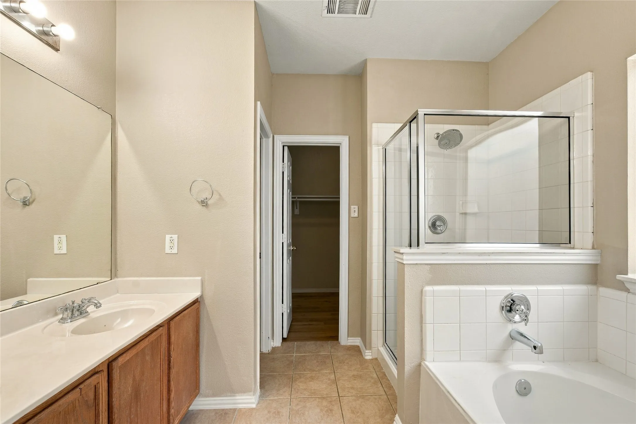 Dual vanity with an integrated sink, polished chrome faucet, and wood-finish cabinetry