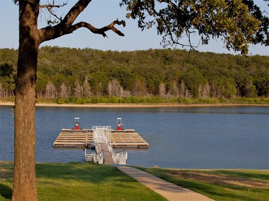 Dock area featuring a water view and a forest view