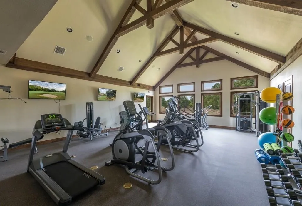 Exercise room featuring high vaulted ceiling and beamed ceiling