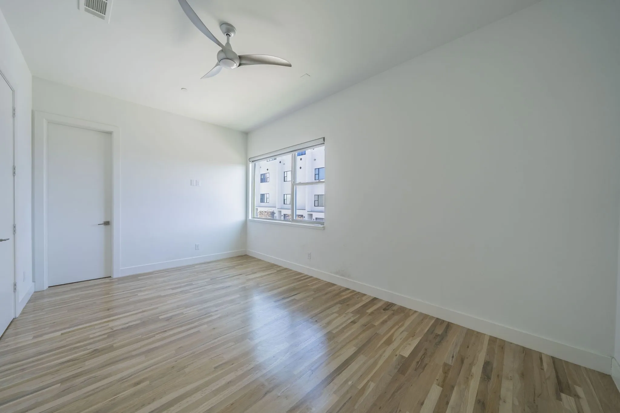 Unfurnished room with light wood finished floors and a ceiling fan