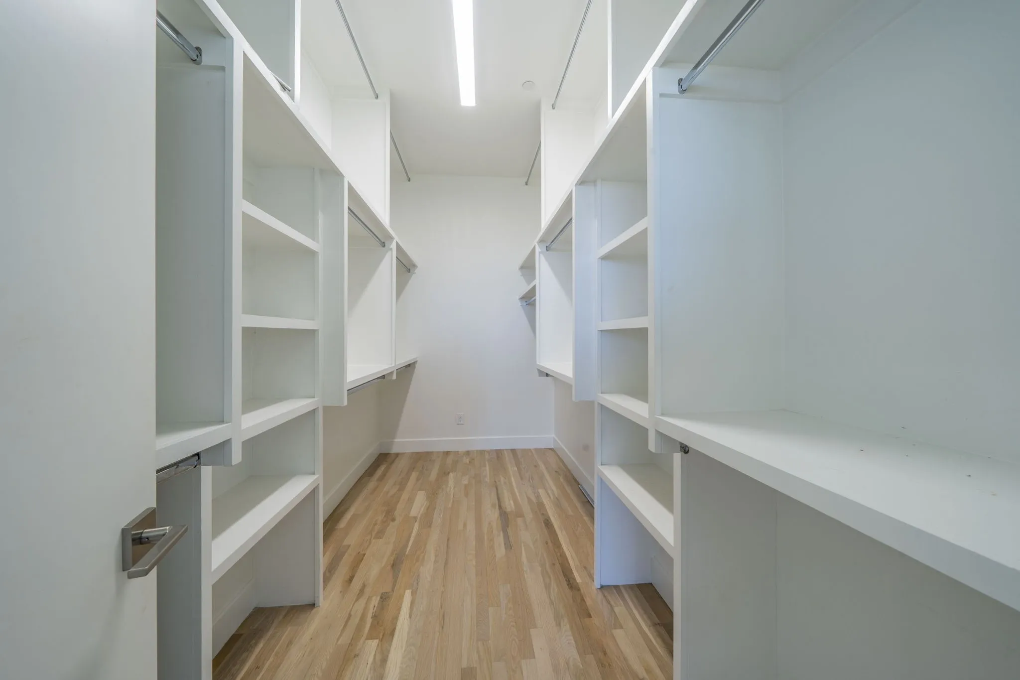 Spacious closet featuring light wood-style flooring