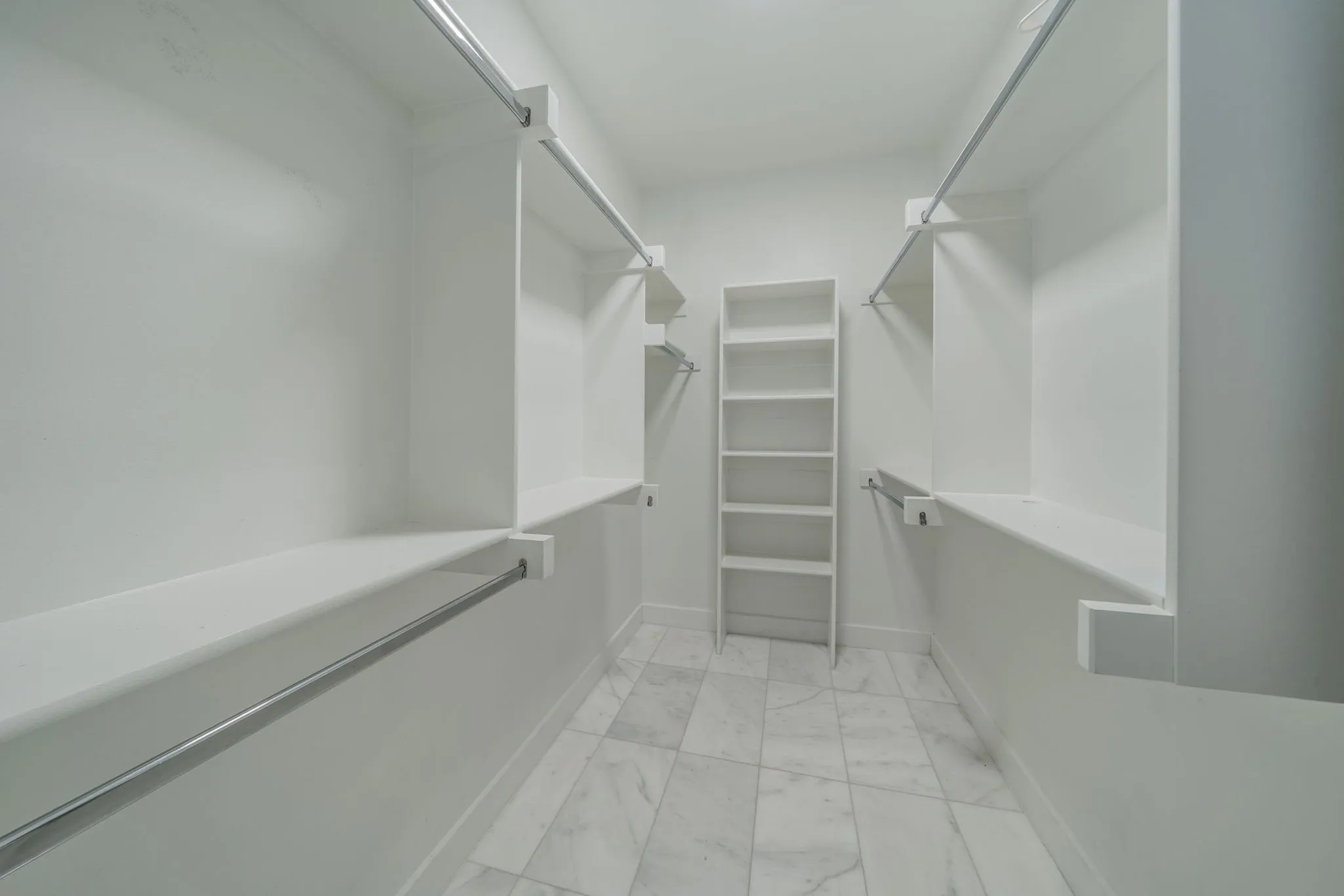 Walk in closet with light marble finish floors