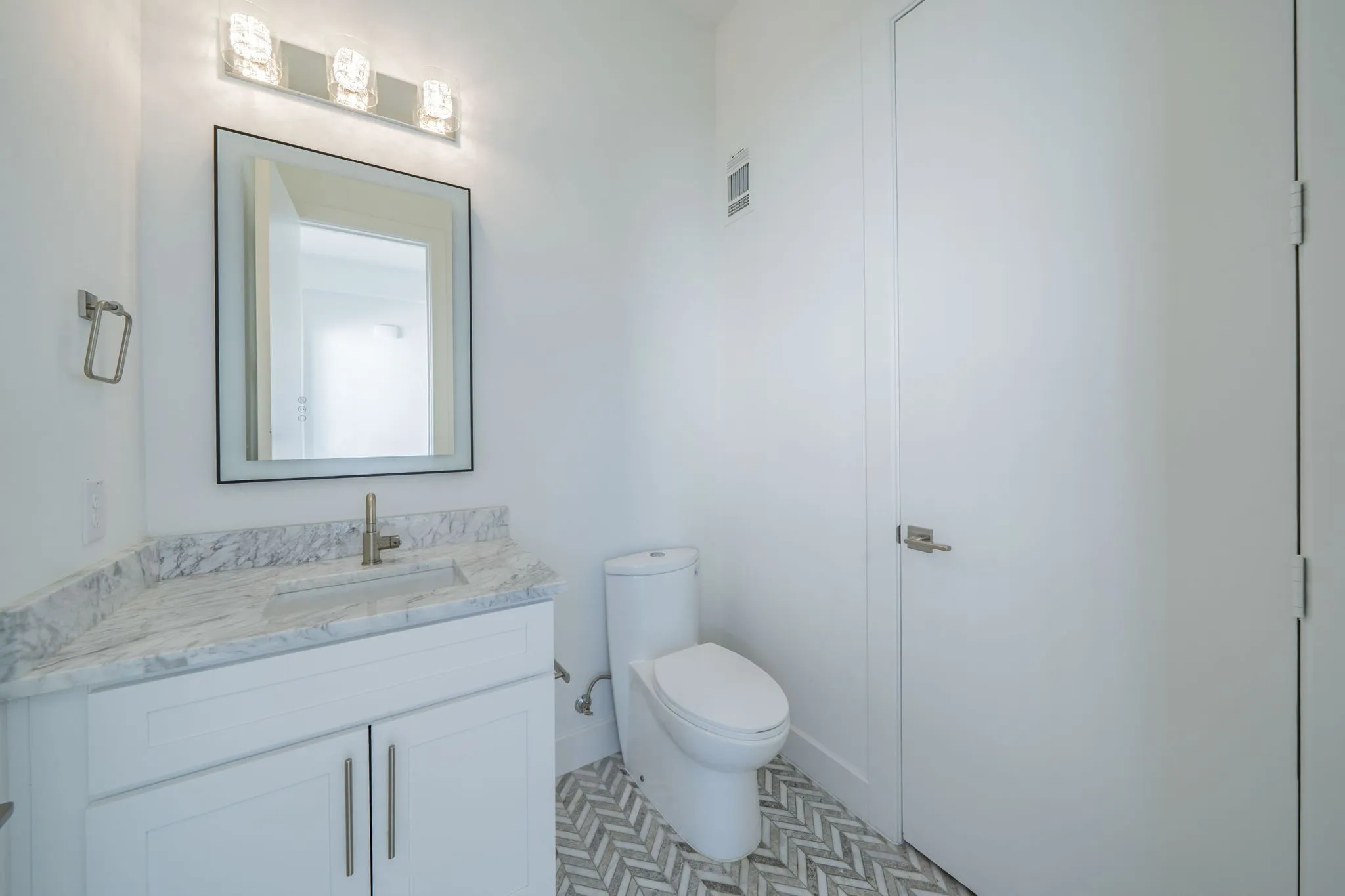 Half Bath with vanity and toilet. 4th level bath