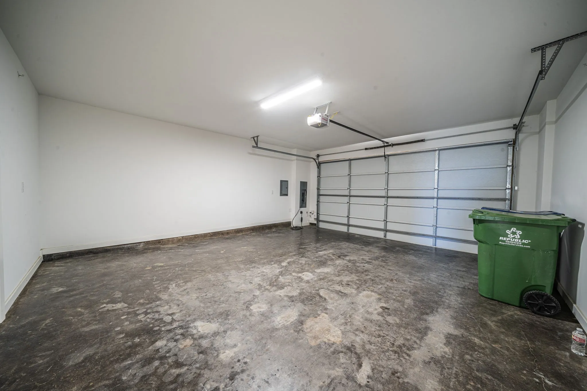 Garage with baseboards and a garage door opener