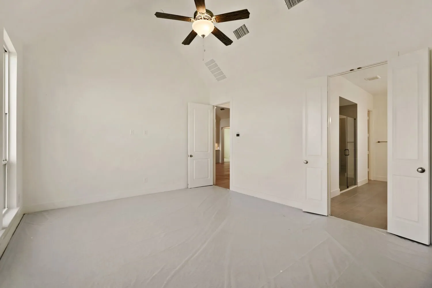 Unfurnished bedroom featuring ceiling fan and lofted ceiling