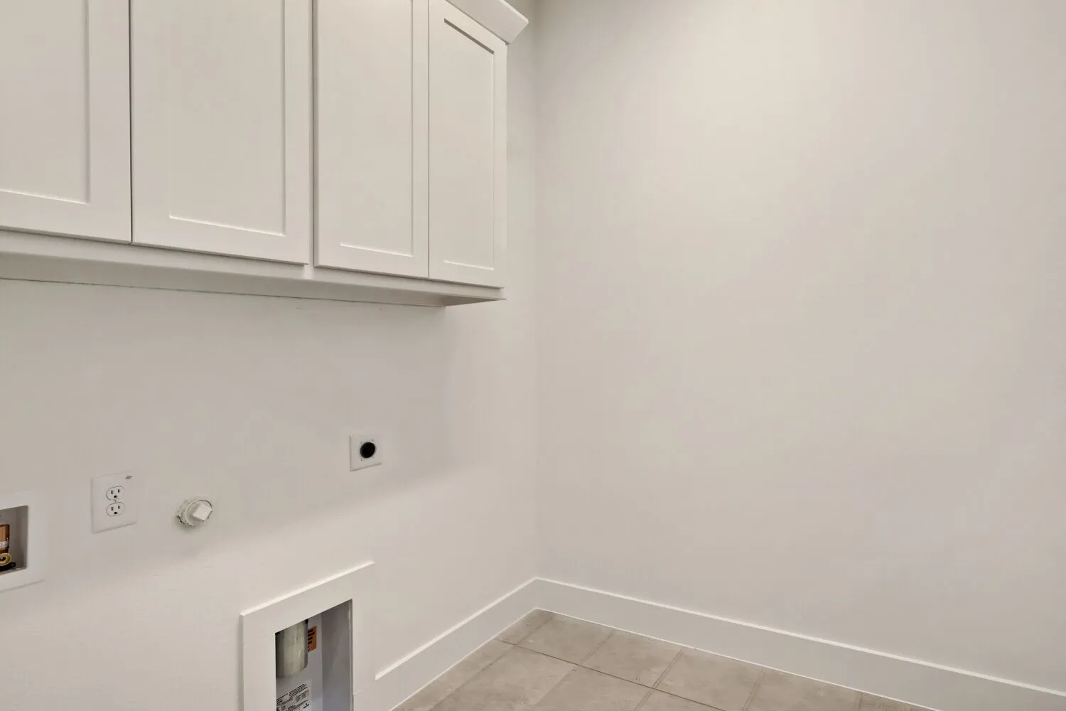 Laundry area with cabinet space, light tile patterned floors, hookup for a gas dryer, hookup for an electric dryer, and hookup for a washing machine