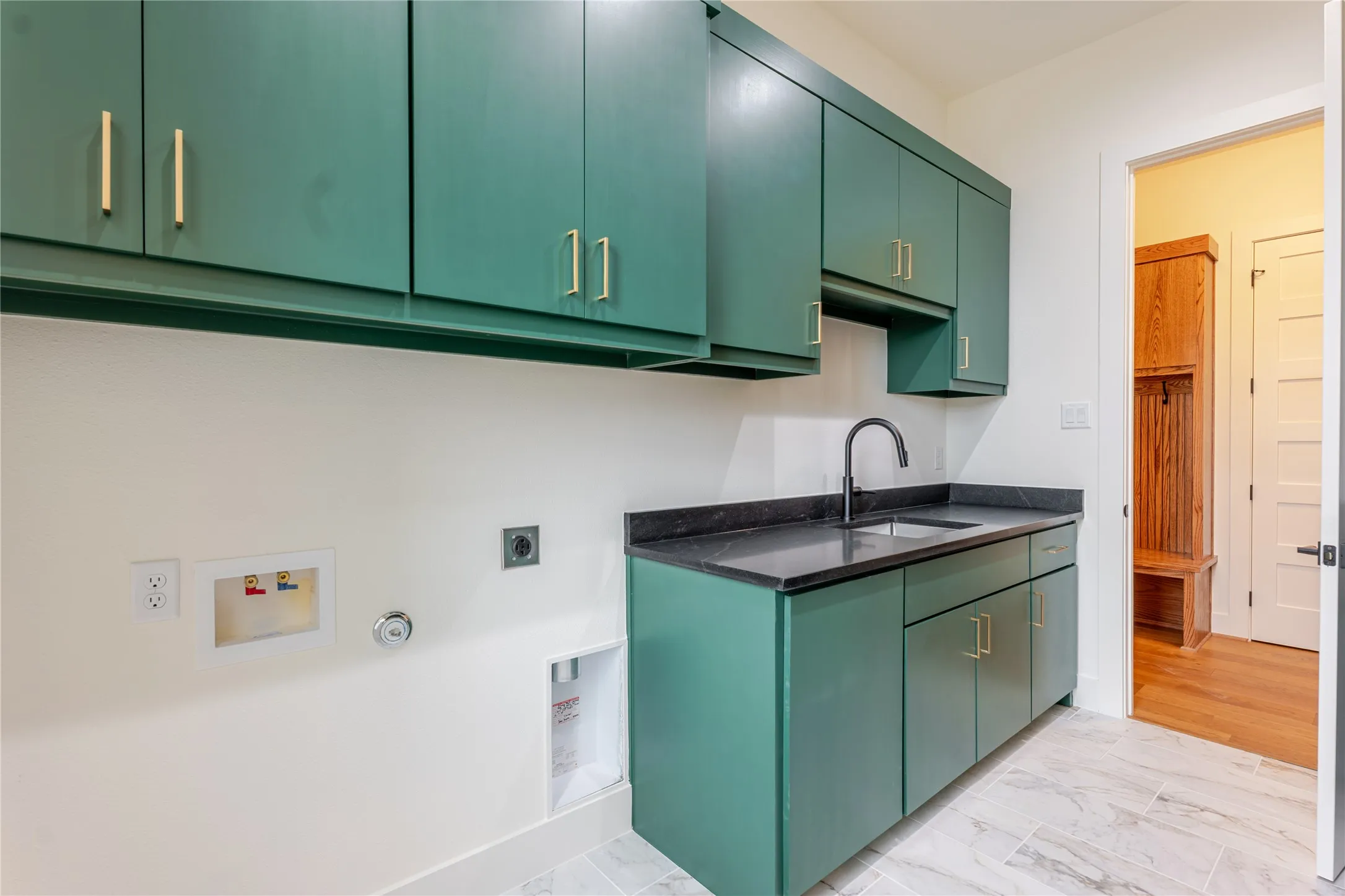 Laundry area featuring light marble finish floors, hookup for an electric dryer, hookup for a gas dryer, cabinet space, and hookup for a washing machine