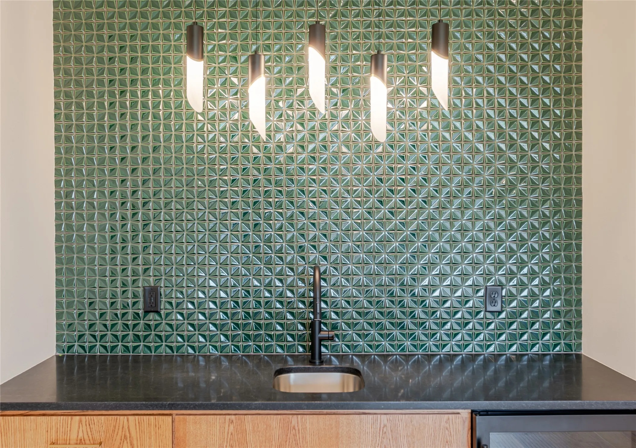 Kitchen view of dark stone counters and a sink