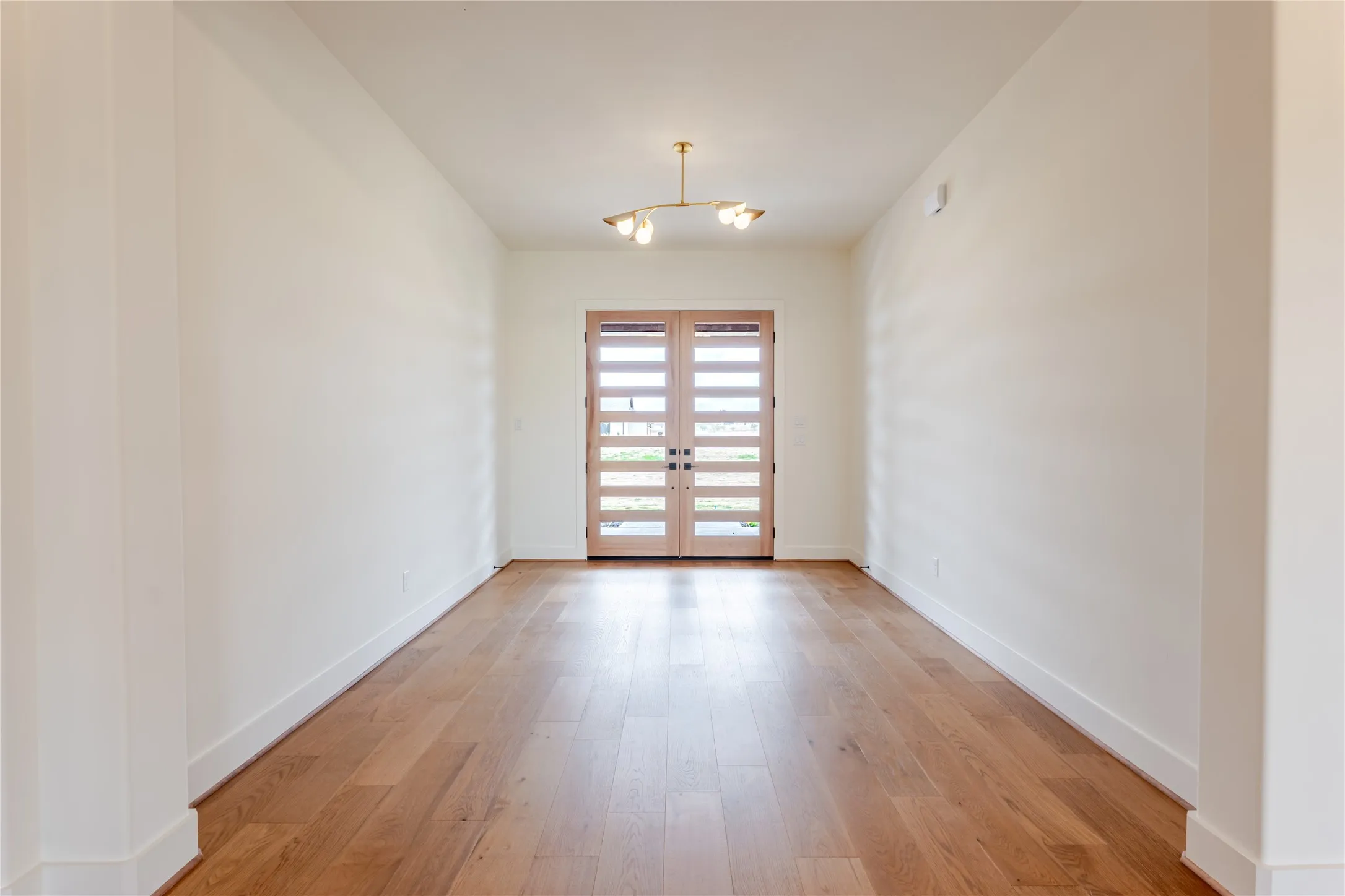 Unfurnished room featuring french doors and light wood-style flooring