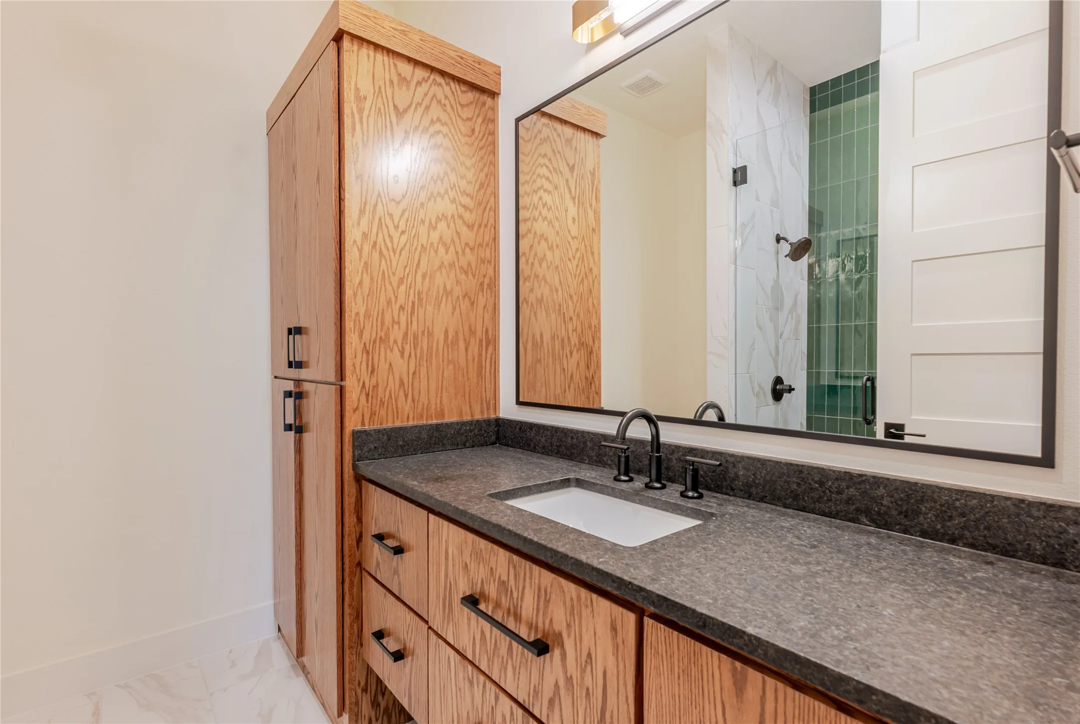 Full bathroom with vanity, light marble finish floors, and a tile shower