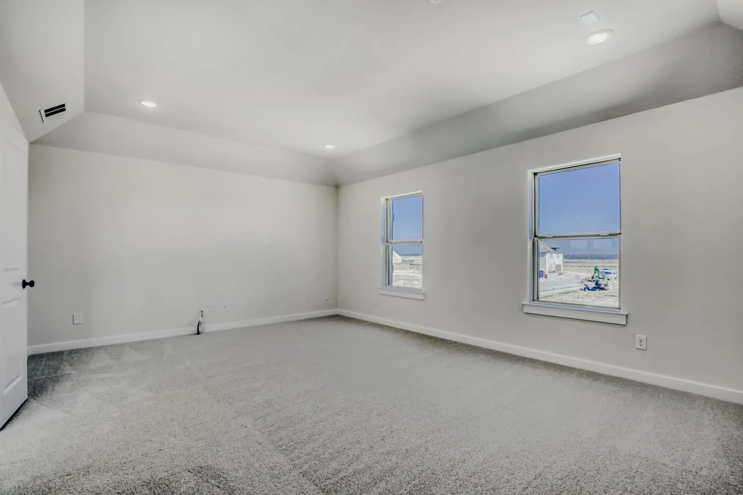 Spare room with lofted ceiling, light carpet, and recessed lighting