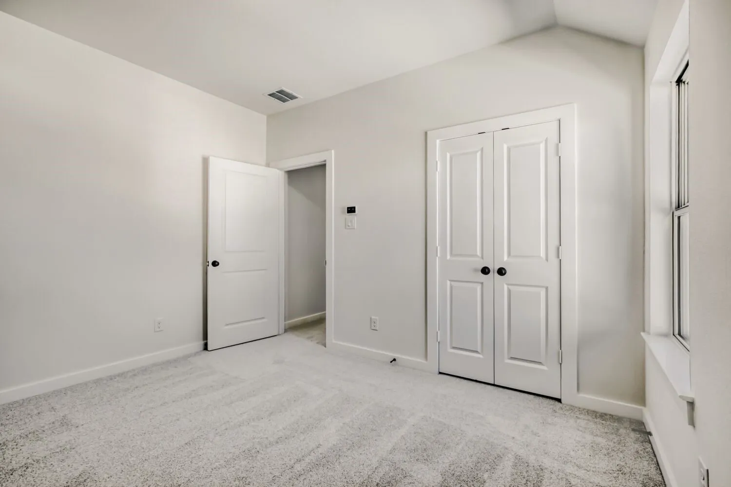Unfurnished bedroom with light colored carpet and a closet