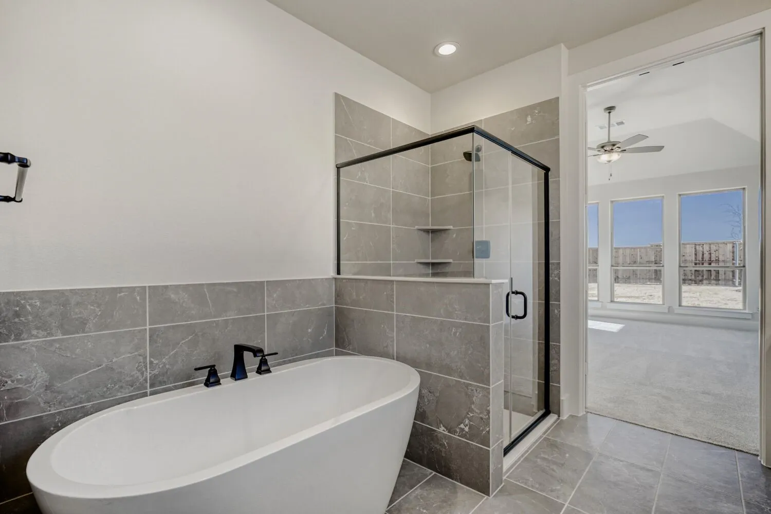Full bath featuring a shower stall, a freestanding bath, tile walls, a ceiling fan, and recessed lighting