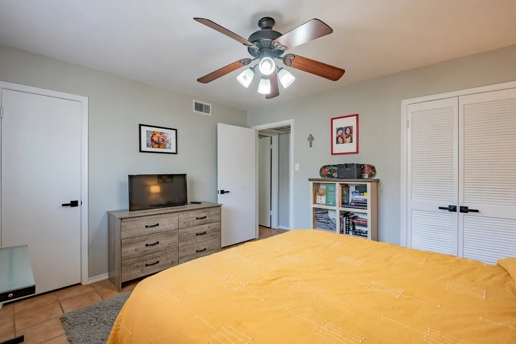 Bedroom featuring light tile patterned flooring, a ceiling fan, and a closet