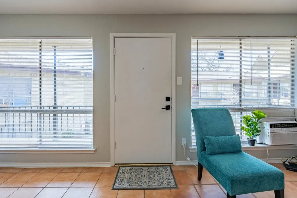 Foyer entrance with light tile patterned flooring, healthy amount of natural light, and cooling unit