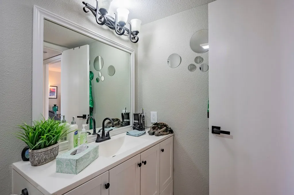 Bathroom featuring a textured wall and vanity