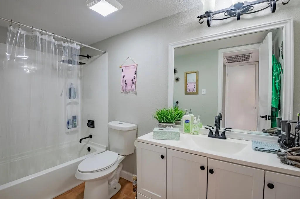 Bathroom with shower / bathtub combination with curtain and vanity