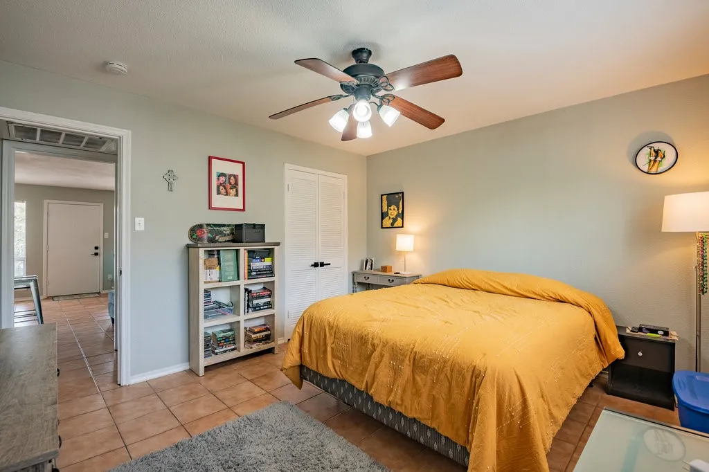 Bedroom featuring light tile patterned floors, a closet, and ceiling fan