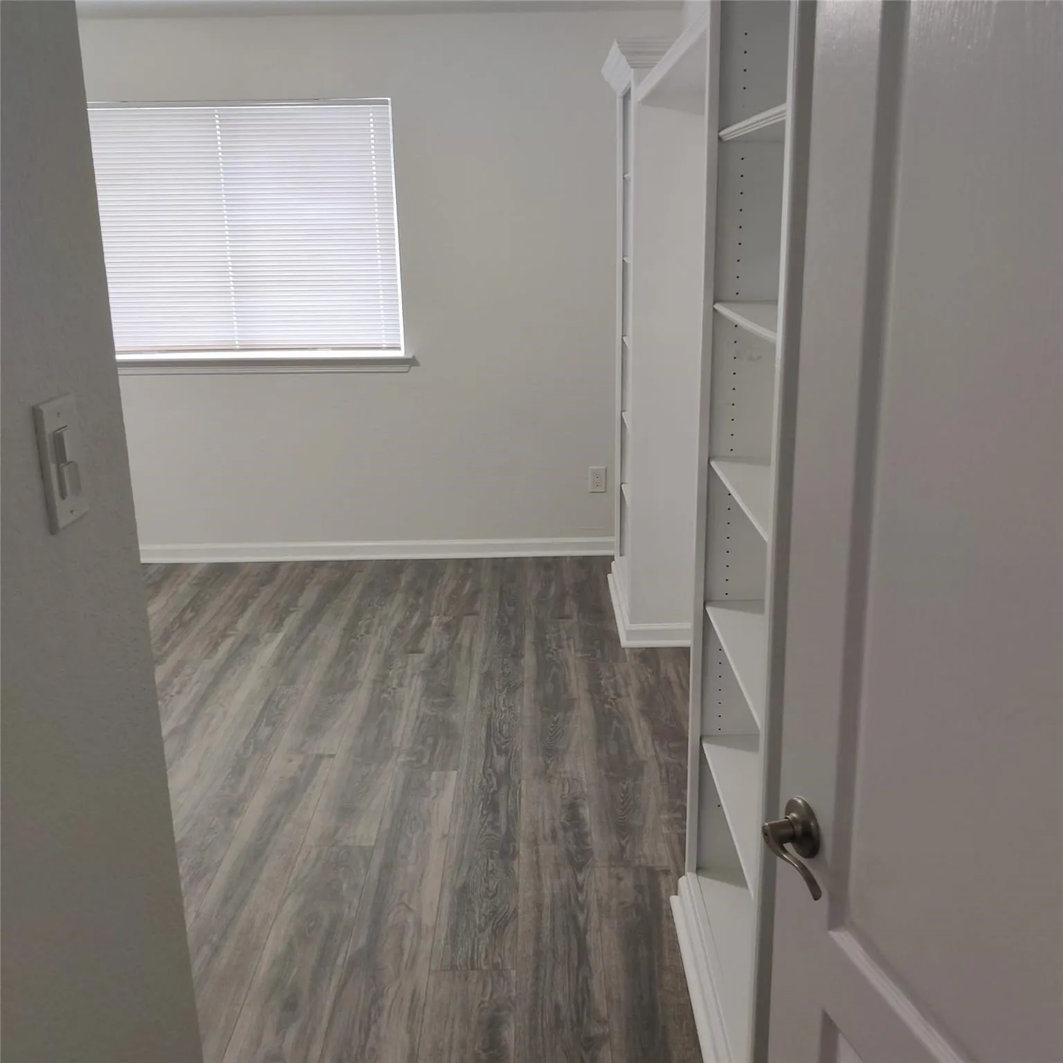 Walk in closet with dark wood-style flooring