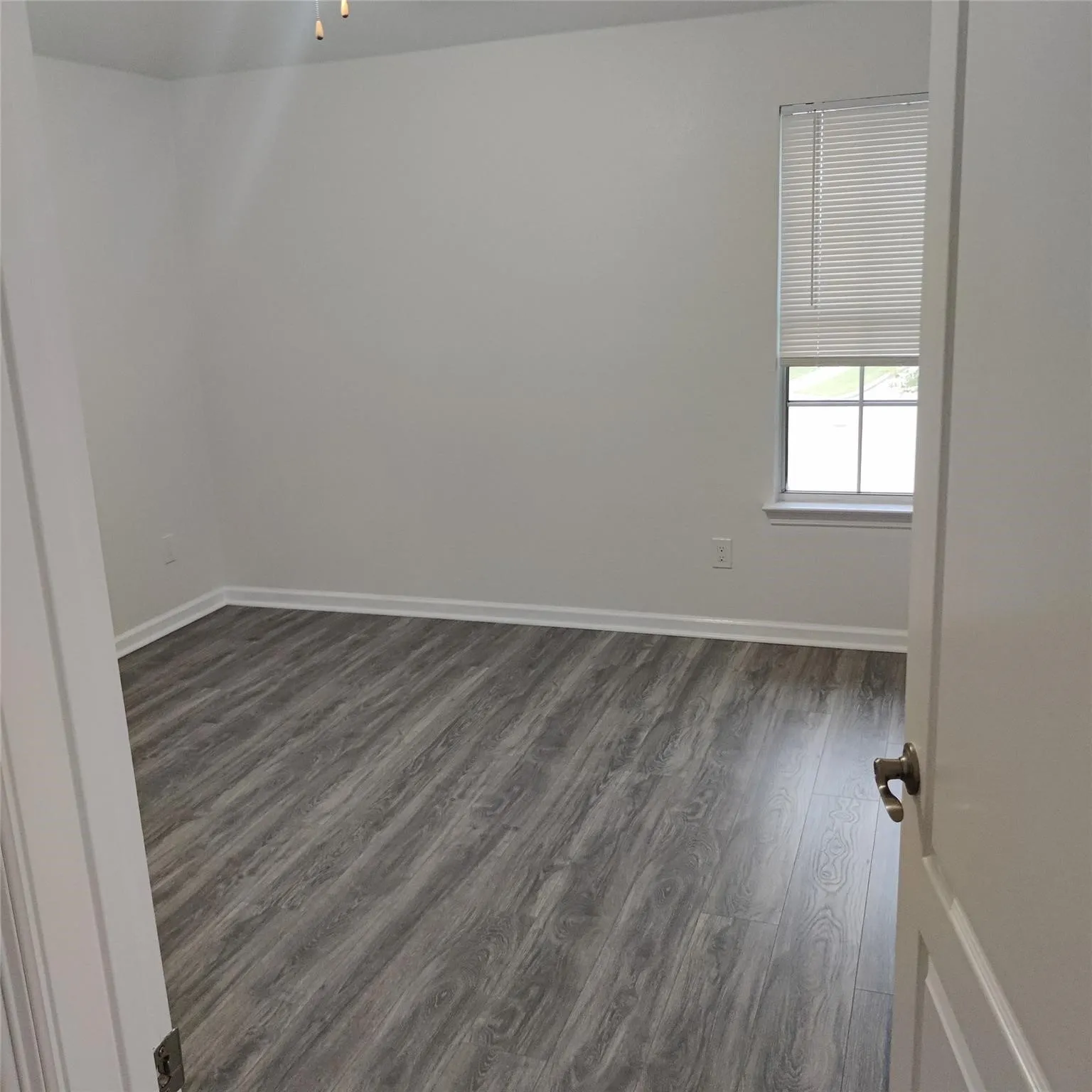 Empty room featuring dark wood finished floors and baseboards